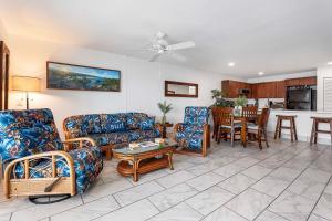 a living room with couches and a table and a kitchen at Sea Village 4108 in Kailua-Kona