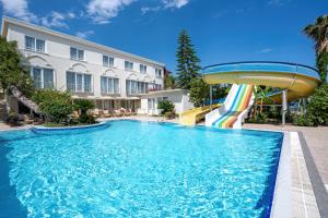 une piscine avec toboggan en face d'un bâtiment dans l'établissement Club Marakesh Hotel - All inclusive, à Antalya