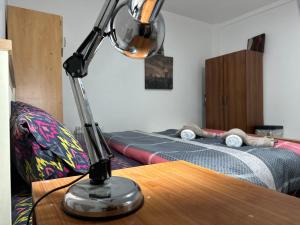 a lamp sitting on top of a table with a bed at Reat Bungalow of 207A in London