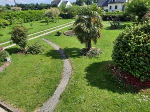 un jardín con una palmera en el césped en Breizh Horizon, en Tréméven