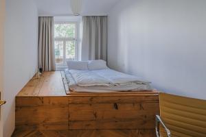 プラハにあるArt hotel Sazavskaの窓付きの客室で、木製のプラットフォーム上のベッド1台を利用します。