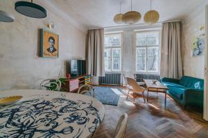 a bedroom with a bed and a living room with a couch at Bohemian Experience in Prague
