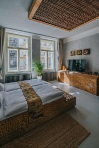 a bedroom with a large bed and two windows at Bohemian Experience in Prague