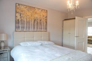 une chambre avec un lit avec un tableau sur le mur dans l'établissement Creggan Deveskey Cottage, à Carrickmore