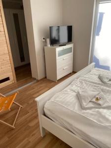 um quarto com uma cama e uma televisão numa cómoda em Fehmarnliebe em Fehmarn
