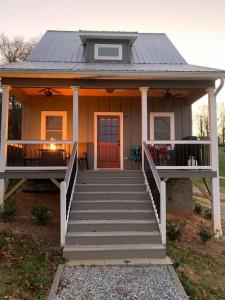 a small house with a porch and a door at A beautiful sunset cottage in Hendersonville
