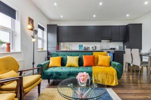 un soggiorno con divano verde e tavolo di Spacious 3 Bedroom - 2 Full Bath Flat Belverde Erith South East London a Belvedere