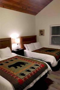 a hotel room with two beds with a rug on them at A beautiful sunset cottage in Hendersonville +12 photos