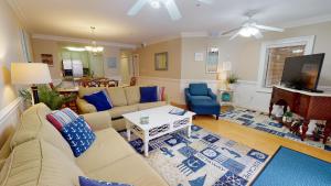 a living room with a couch and a tv at Brass Rail Villas 109 by Tybee Vacation Rentals in Tybee Island