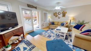a living room with a flat screen tv and a couch at Brass Rail Villas 109 by Tybee Vacation Rentals in Tybee Island
