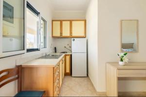 kuchnia z białą lodówką i oknem w obiekcie Villa Dimitra - Amazing sea view w mieście Poros +41 zdjęć