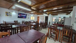 un restaurant avec des tables et des chaises en bois et une télévision dans l'établissement Villa Termal, à Federación
