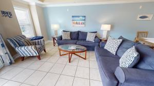 un soggiorno con un divano e sedie blu di Gull Reef 614 by Tybee Vacation Rentals a Tybee Island