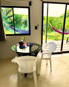 a dining room with a glass table and two chairs at Deer House Cabuya in Cabuya