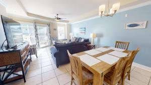 una sala da pranzo e un soggiorno con tavolo e divano. di Gull Reef 614 by Tybee Vacation Rentals a Tybee Island Altre 41 foto