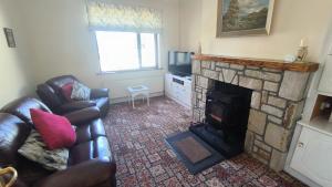 - un salon avec un canapé et une cheminée dans l'établissement Swinford Country House, à Swinford