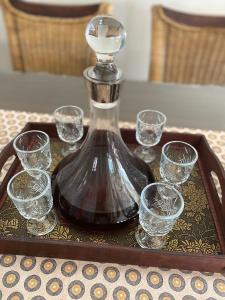 um decantador e copos numa bandeja sobre uma mesa em The Gables-Clarens em Clarens