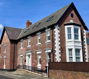 a red brick building with a black roof at Wellington house in Blythe