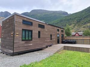 a small wooden house with mountains in the background at Microen in Stryn