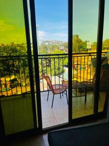 einen Balkon mit einem Stuhl und Stadtblick in der Unterkunft The home hive apartment in Kampala
