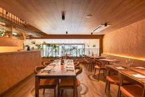 uma sala de jantar com mesas e cadeiras de madeira em Wellcomm Spa & Hotel em Medellín