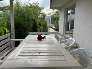 een rode roos op een houten tafel op een veranda bij Sanny’s house in Ezerets