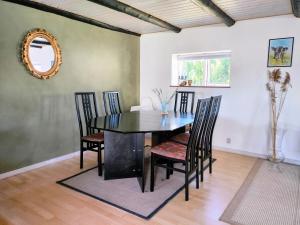 a dining room with a black table and chairs at Ferielejlighed i smukke omgivelser in Ørsted