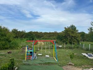un parque infantil en un campo con columpios en Sanny’s house, en Ezerets