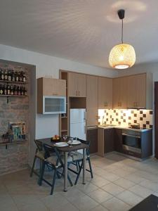 una cucina con tavolo con sedie e frigorifero di Plaka Elounda cozy apartment a Eloúnda
