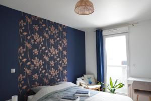 een slaapkamer met een blauwe muur met bloemenbehang bij Charmant Appartement au Pré in Pré Saint Gervais
