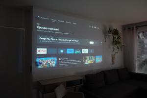 een groot scherm in een woonkamer met een bank bij Charmant Appartement au Pré in Pré Saint Gervais