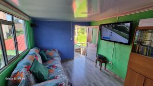 a living room with a couch and a flat screen tv at Vivienda Rural La Estancia in Duitama
