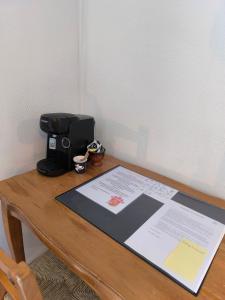 a table with a coffee maker and a paper on it at Auberge De Calendal in Aiglun