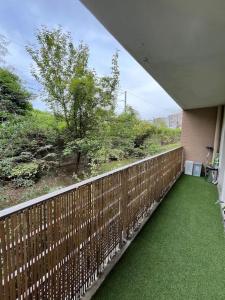 a balcony with green grass and a view of a hill at Appartement Paisible au Vert in Saint-Ouen
