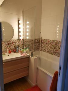 a bathroom with a sink and a tub and a mirror at Maison du bonheur in Lanton