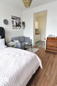 a bedroom with a white bed and a couch at Luxus Appartement in zentrale Lage von Siegburg in Siegburg