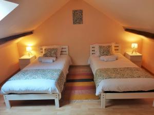 2 Betten in einem Zimmer mit orangefarbenen Wänden in der Unterkunft Gîte La Petite Fagette in Frayssinet-le-Gélat