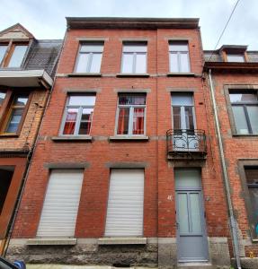 a red brick building with windows and a door at Le West - Dinant Centre in Dinant