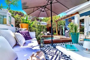 eine Terrasse mit einem Sofa und einem Sonnenschirm in der Unterkunft Casa Bambou An hidden gem near Saint Tropez with private pool in Gassin