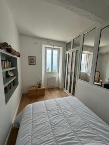 sypialnia z dużym białym łóżkiem i oknem w obiekcie Joli deux pièces vieux village de Roquebrune-Cap-Martin w mieście Roquebrune-Cap-Martin