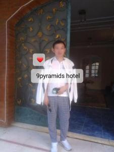 een jonge jongen staat voor een muur bij 9pyramids hotel in Caïro