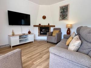 ein Wohnzimmer mit einem Sofa und einem TV in der Unterkunft Casa Ressagosa - Plus Costa Brava in L'Estartit