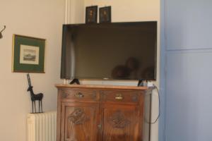 uma grande televisão de ecrã plano em cima de uma cómoda de madeira em Classic apartment in Kalamata em Kalamata