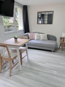 uma sala de estar com uma mesa e um sofá em Appt dans maison typique avec jardin privé em Chinon