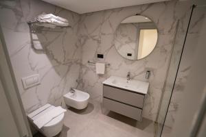 a bathroom with a sink and a toilet and a mirror at Le Rio Appart-Hotel City Center in Tangier