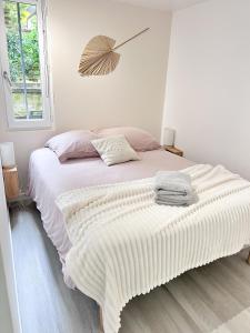 um quarto com uma grande cama branca e uma janela em Appt dans maison typique avec jardin privé em Chinon
