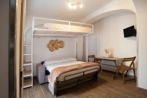 ein Schlafzimmer mit einem Etagenbett und einem Schreibtisch in der Unterkunft Il Vicoletto sul Mare in Ischia