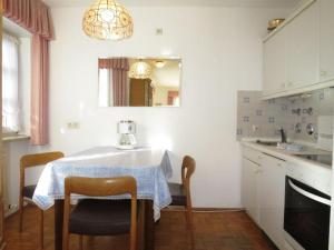 cocina con mesa, sillas y fregadero en Ferienwohnung am Karlspark, en Bad Reichenhall