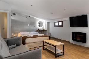 a bedroom with a bed and a couch and a fireplace at Complejo Mirador del Castillo in Alcalá del Júcar