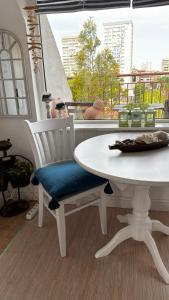 einen weißen Tisch und Stuhl mit einem Tisch und einem Fenster in der Unterkunft Studio San Stefano in Burgas City